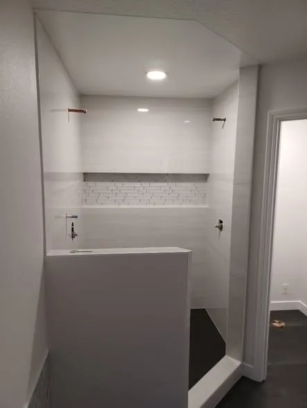 Walk-in shower with half wall and white tile